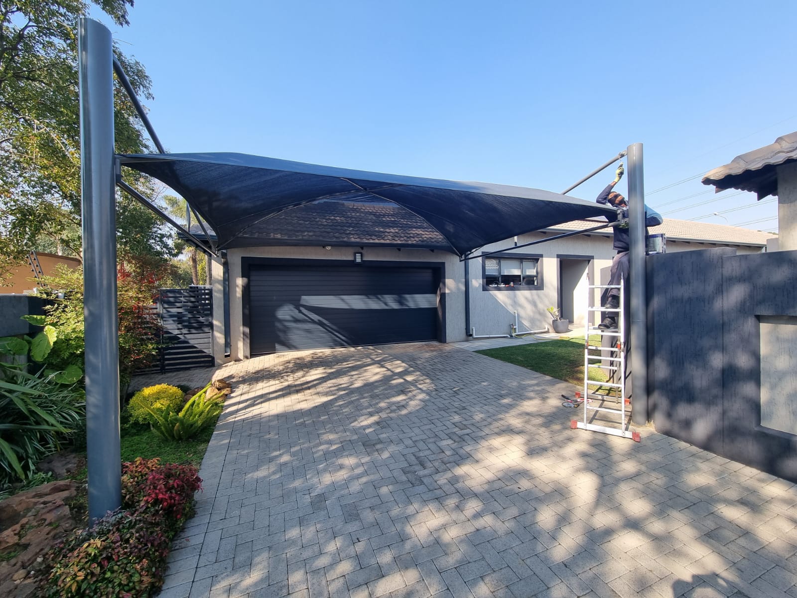 Charcoal shadeport over a landscaped residential driveway